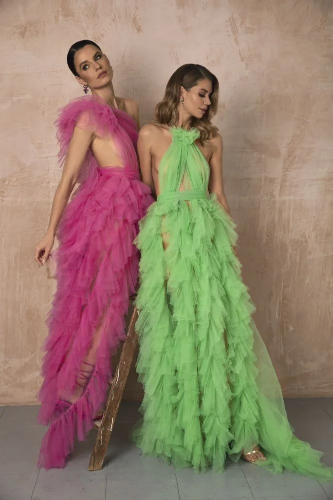 two models wearing green and pink ruffle and tulle dresses vening akeup