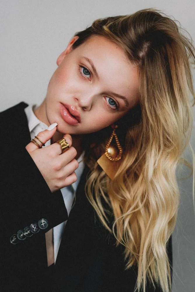 blond model wearing black men's blazer and gold statement earings