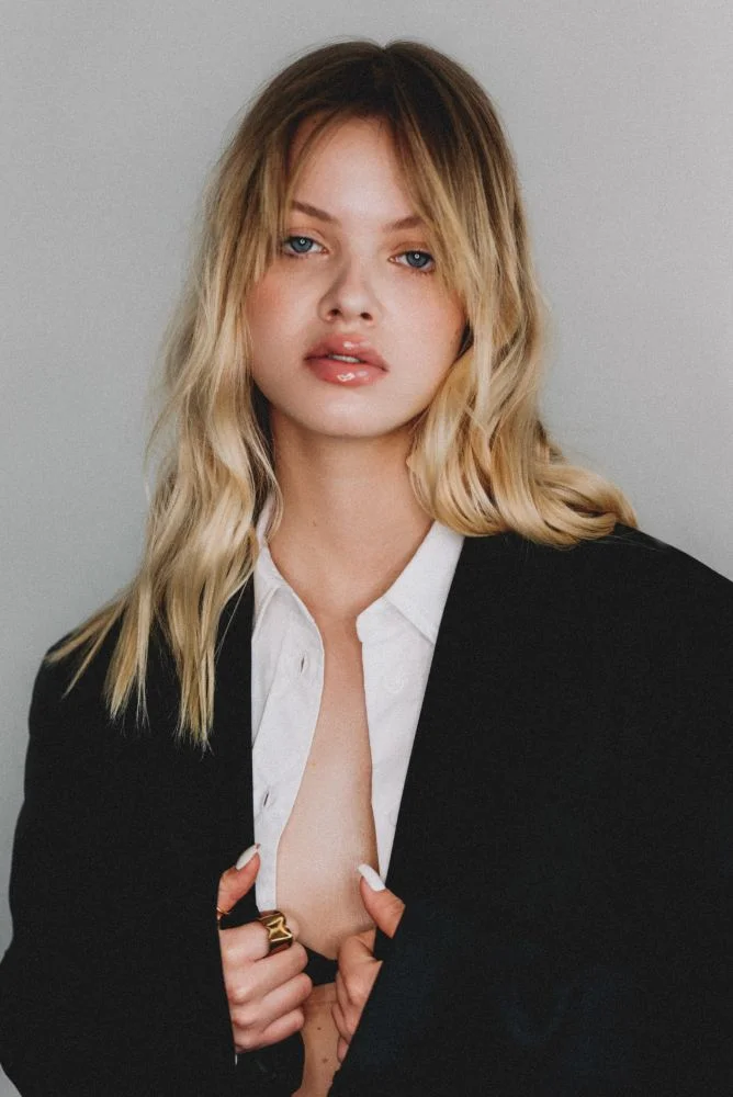 blond girl wearing men's black blazer and white shirt